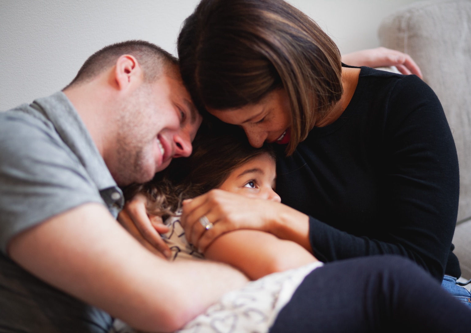 Mom and Dad hugging their daughter
