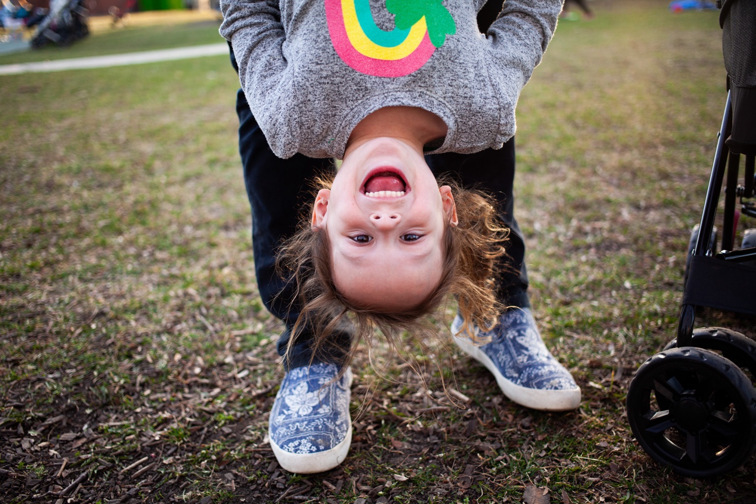 A dad holding his daughter upside-down